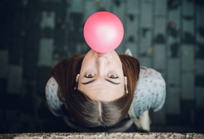 Woman looking up with pink bubble gum