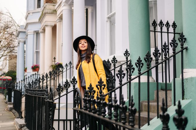 Cheerful woman standing in stairs in typical london buildings