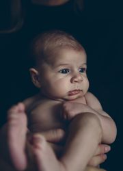 Nude baby posing in her mother's arms