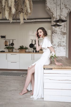 young pensive lady with red lips in white dress looking away and contemplating