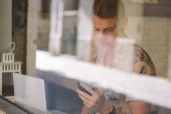 Man talking on smartphone while browsing laptop