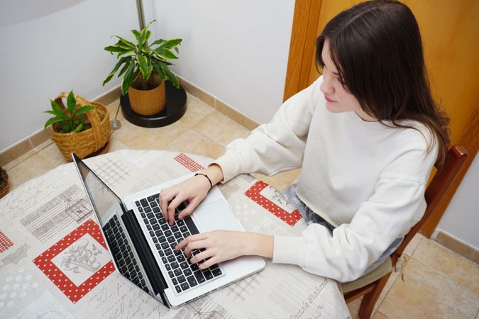 Teenage girl using laptop at home