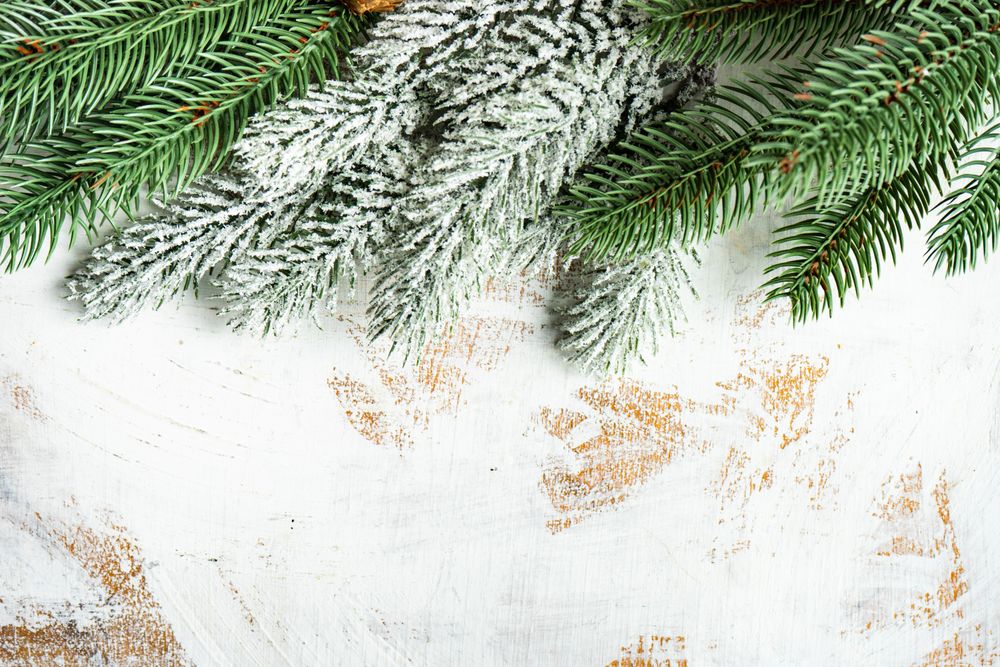 Christmas themed frame with fir tree branches and holiday decoration on rustic background with copy space
