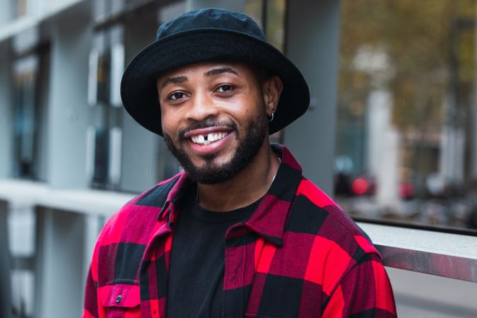 Cheerful Black man in stylish outfit on street