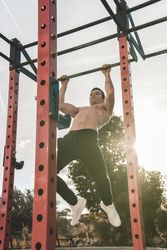 Man doing pull ups on street