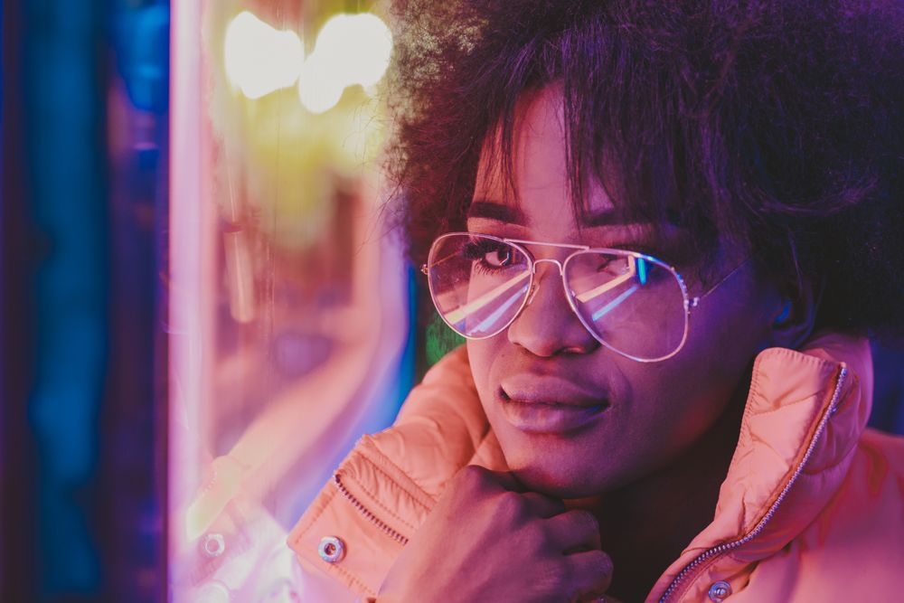 Black woman standing on night city street