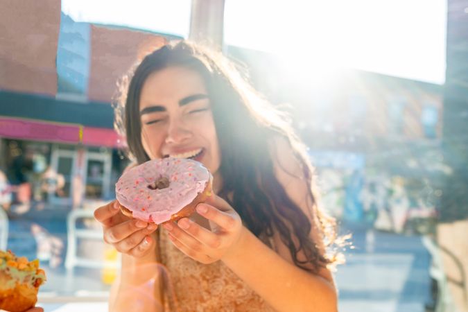 Woman enjoying tasty donut in cafe