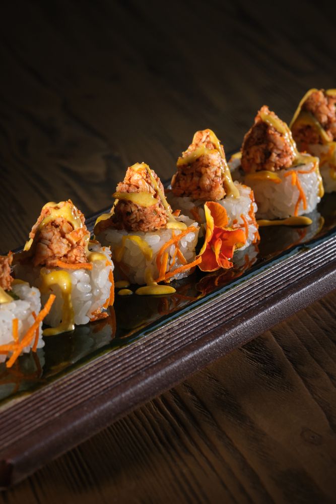 Appetizing sushi topped with salmon and fresh sauce