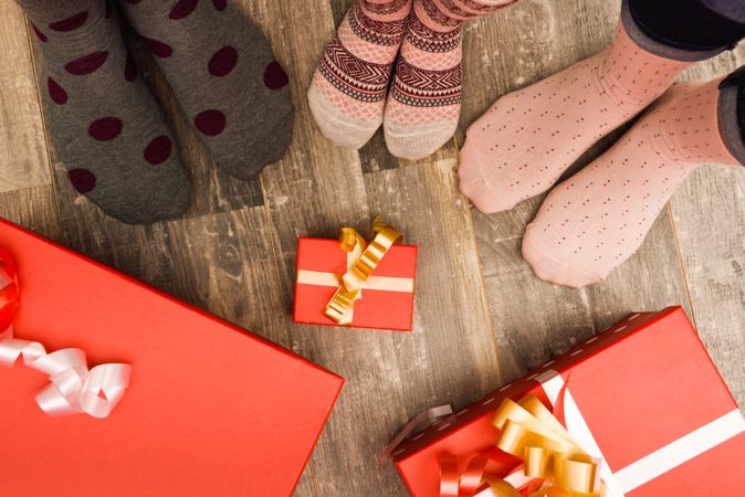 Feet of three people on wood floor during Christmas