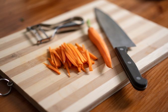 Julienne carrots cutting board kitchen knife peeler fresh vegetables healthy cooking preparation food