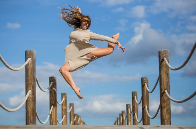 Woman with textile posing in air on footbridge