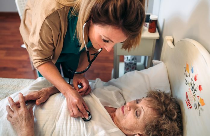 Caregiver auscultating woman