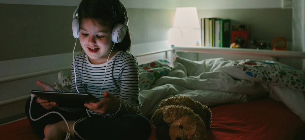Girl with headphones looking at the tablet