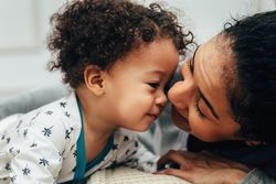 Cute baby boy with his face close to his mother’s
