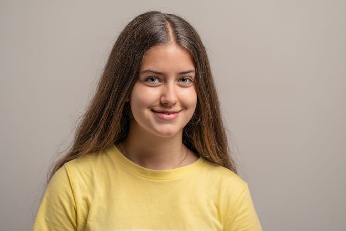 A friendly headshot portrait of a beautiful and happy young woman with a warm smile.