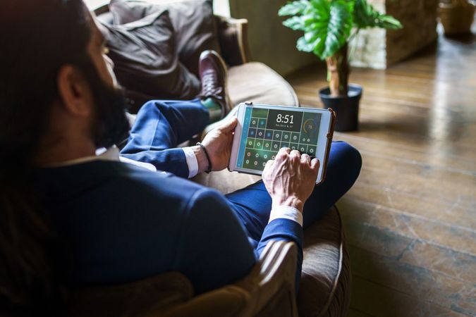 Young adult man using a tablet while sitting on the couch