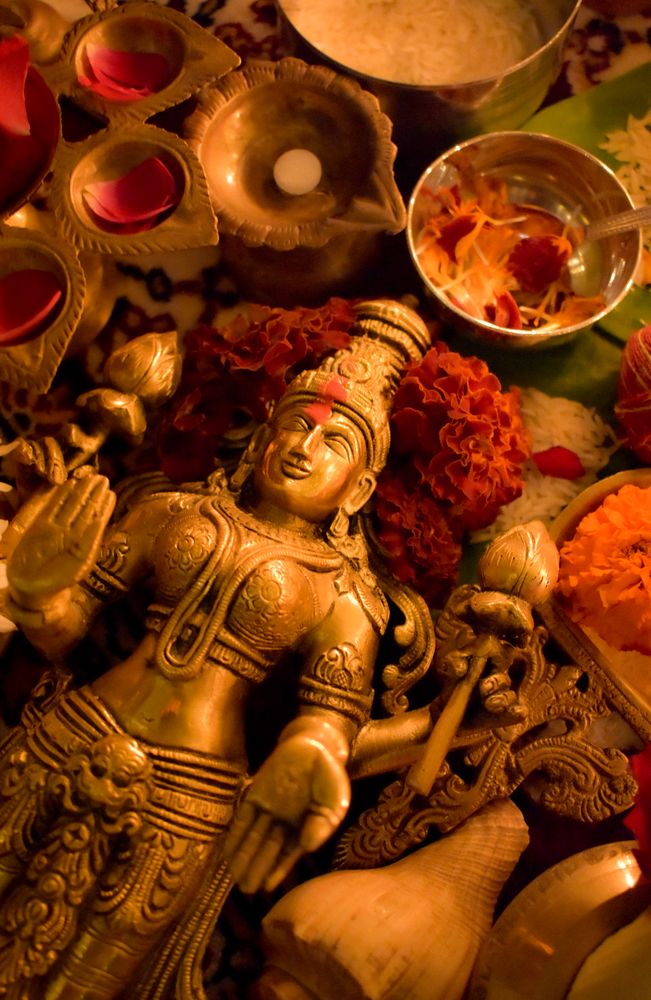 Top view of Buddha golden statue surrounded by diya and flowers