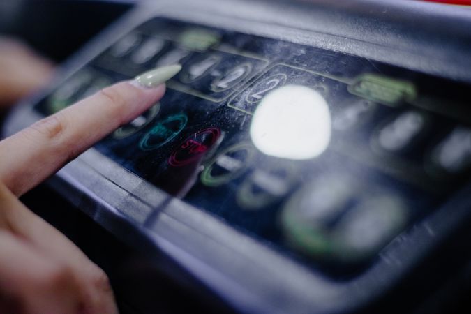 Woman's finger press on a dusty treadmill console for workout