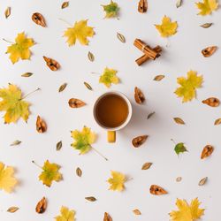 Autumn leaves pattern on light background with coffee