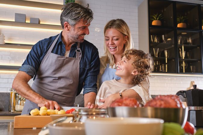 Happy couple teaching son cooking