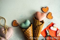 Red heart ornaments in waffle cone with envelope and gift on grey background 0LddKy