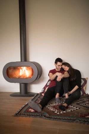 Couple sitting near fireplace on floor