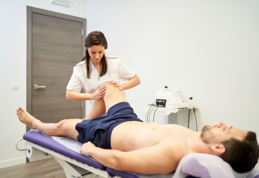 a man receiving a knee treatment at the physiotherapist's office