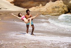 Happy man holding woman on the coast
