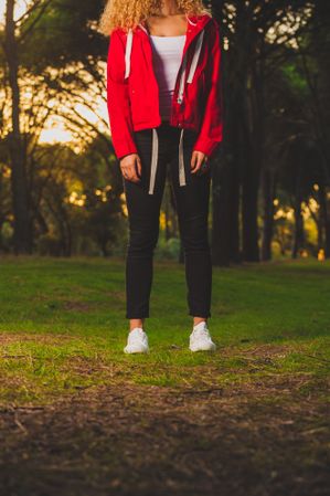 Crop sportive woman standing on meadow