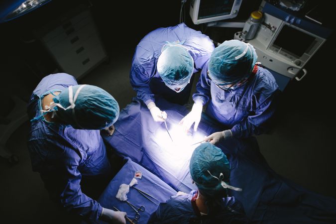 Top view shot of team of surgeons performing surgery in operation theater