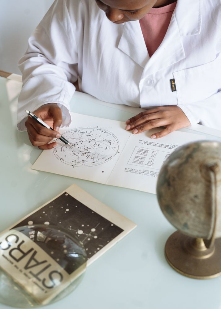 Top view of Black woman drawing a map on a paper