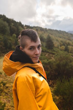 Person in yellow raincoat walking in forest