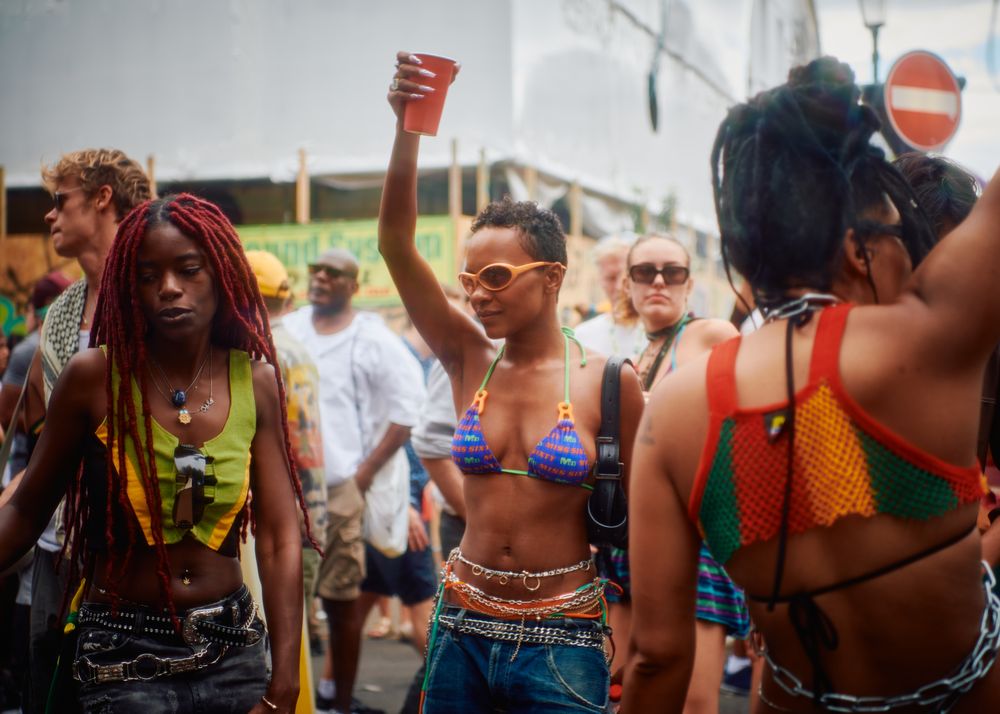 London, England, United Kingdom - August 28, 2022: Woman holding drink up in crowd