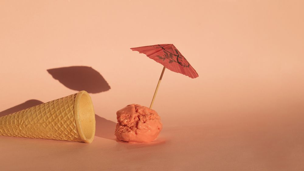 Ice cream cone with ice cream scoop with cocktail parasol