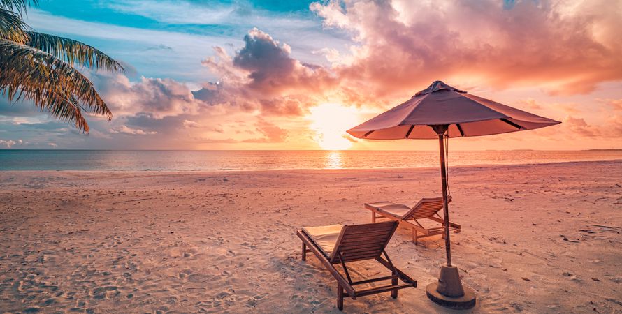 Lounge chairs on the beach with parasol, wide