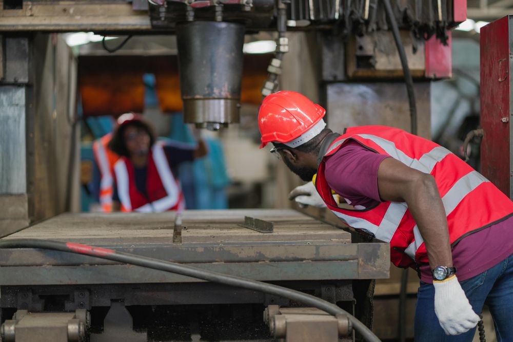 Group of heavy industrial worker checking and repairing big machine in the factory