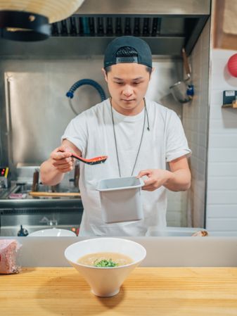 Young cook serving bowl with delicious ramen