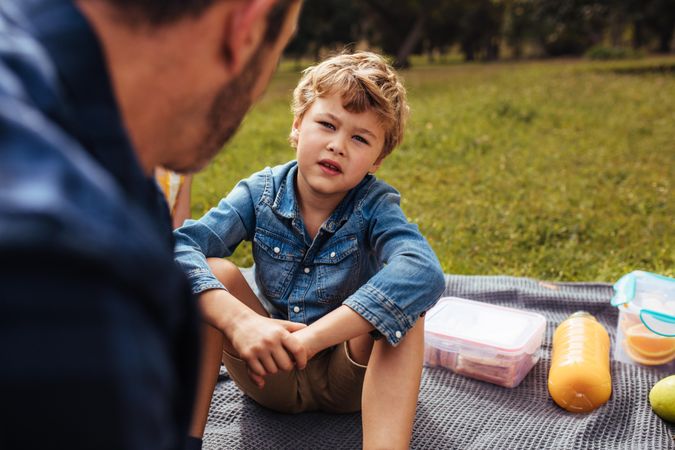 Son having conversation with his dad at picnic