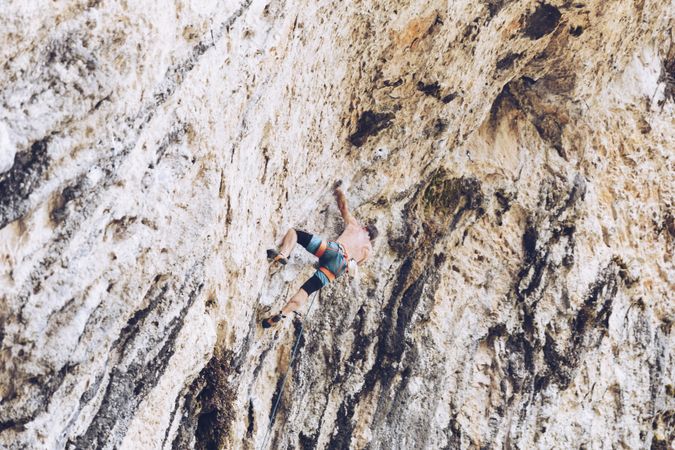 Anonymous man climbing rock