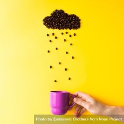 Coffee beans in shape of rainy cloud with purple cup on yellow background beYY3b