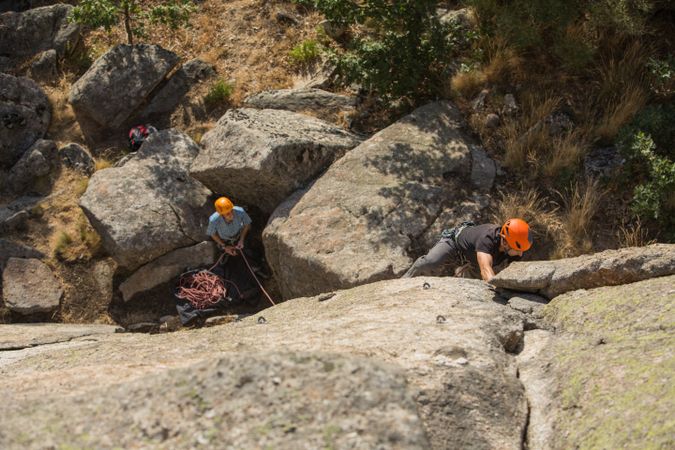 Climbers in safety harness climbing mountain