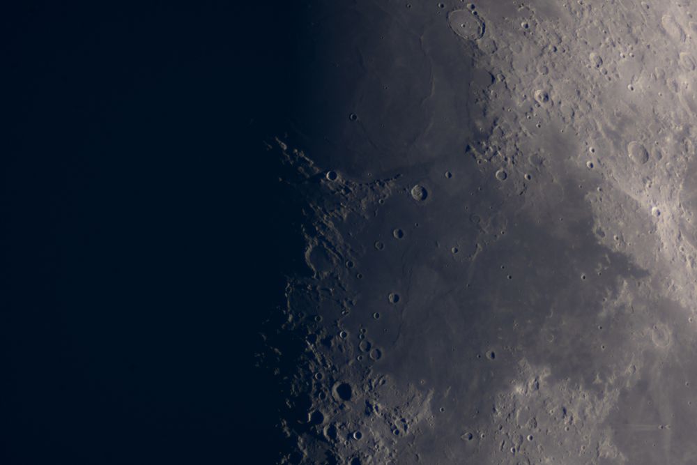 Waxing Moon close-up revealing shadowed lunar craters and plains.