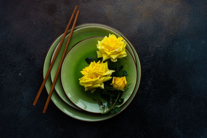 Top view of green table setting with yellow roses