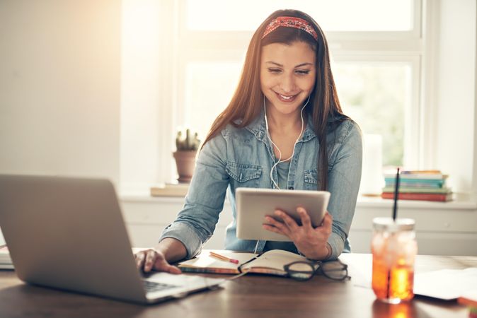 Smiling woman working on laptop in home office with laptop