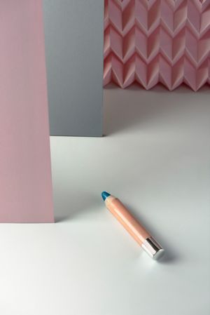 Cosmetic pencils:, make up blue eyeliner pencil, modern background with pink chevron reliefs. make up concept