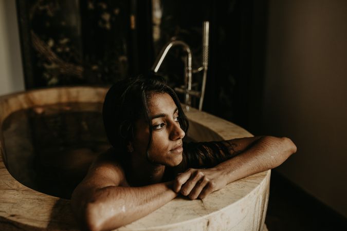 Melancholic Woman sitting and washing in bath