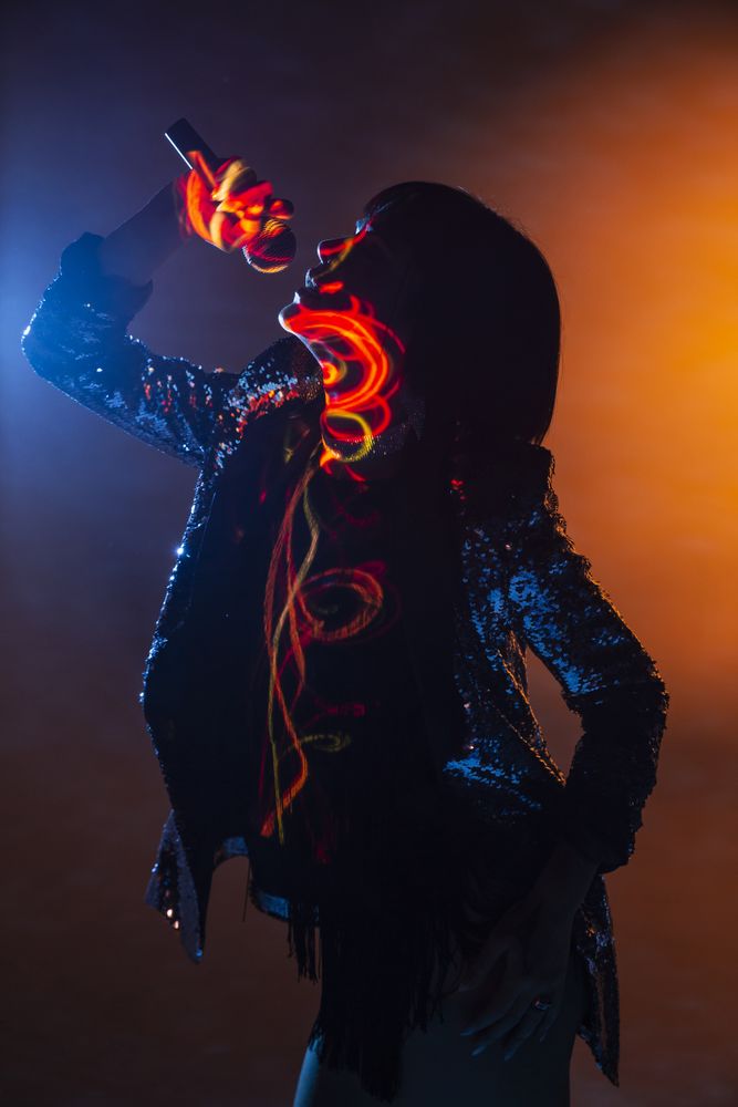 Stylish woman singing on stage