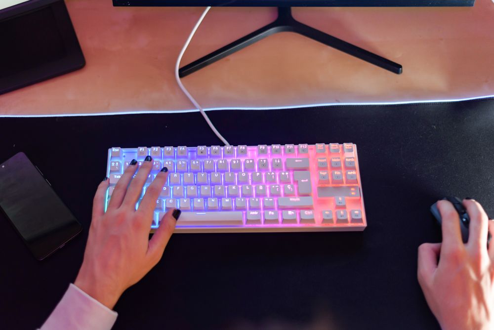 Unrecognizable person sitting with hand on keyboard and using mouse