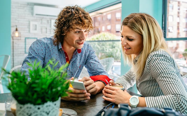 Couple looking mobile at a cafe