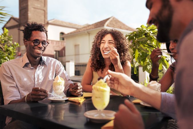 Group of friends laughing at an outdoor cafe in Italy